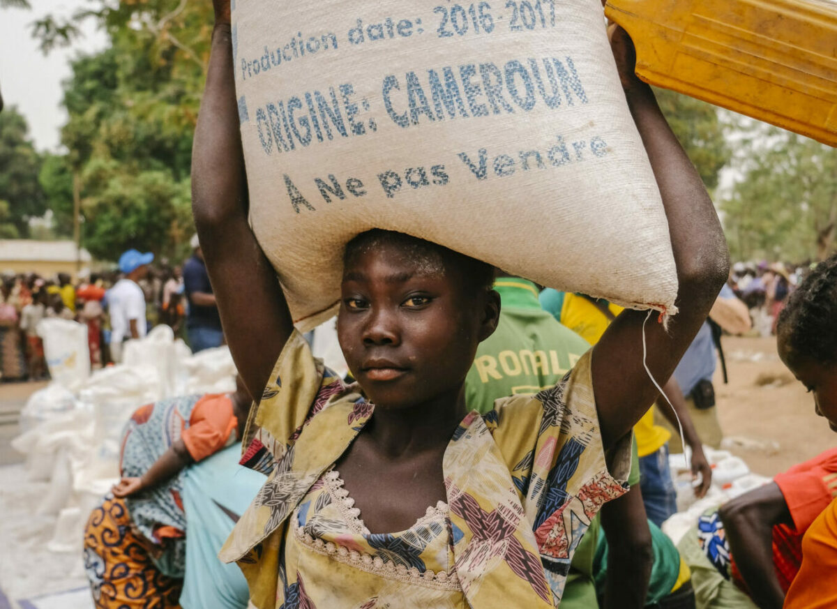 A woman holding a bag of food assistance.